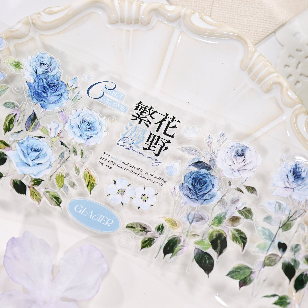 Close-up of Wilderness Rose Glacial Blue Glossy PET die-cut tape with smooth sheen finish and blue rose silhouette on white background