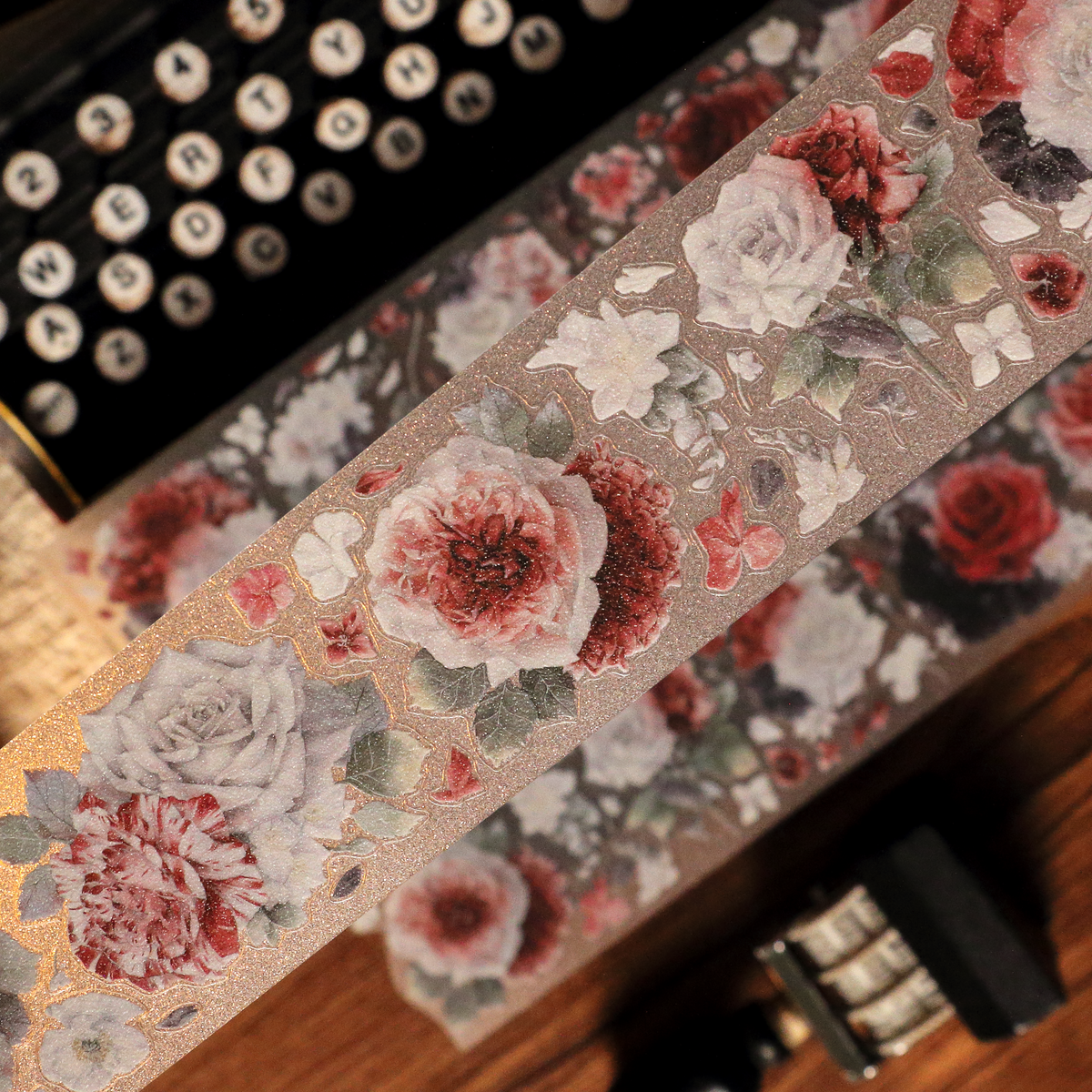 Macro close-up of Scarlet Floral Glitter Sand PET die-cut tape with textured glitter grain and red blossom petal detail