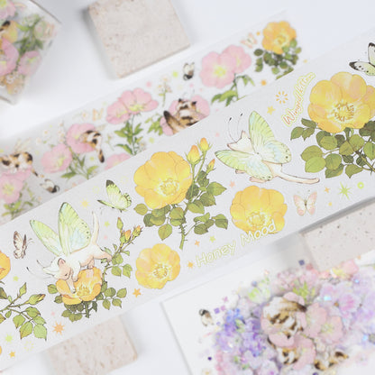 Handheld macro of Watercolor Cute Kittens Sweet Orchard Wildflower Fairy PET tape with muted sage green and warm golden watercolor kitten and wildflower fairy design, sparkling glitter texture and journal elements styled in the background