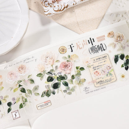 Close-up of Wilderness Rose Glacial Red Glitter Sand PET die-cut tape die-cut edges with sandy sparkle finish and champagne rose motifs in a styled flat lay
